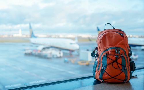 Orange,Backpack,In,An,Airport,Against,A,Plane.,Travel,Touristic mochila de viaje avion - Imagen 1